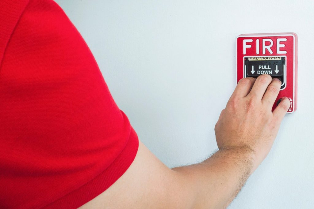 man-is-reaching-his-hand-push-fire-alarm-hand-station_1150-6644